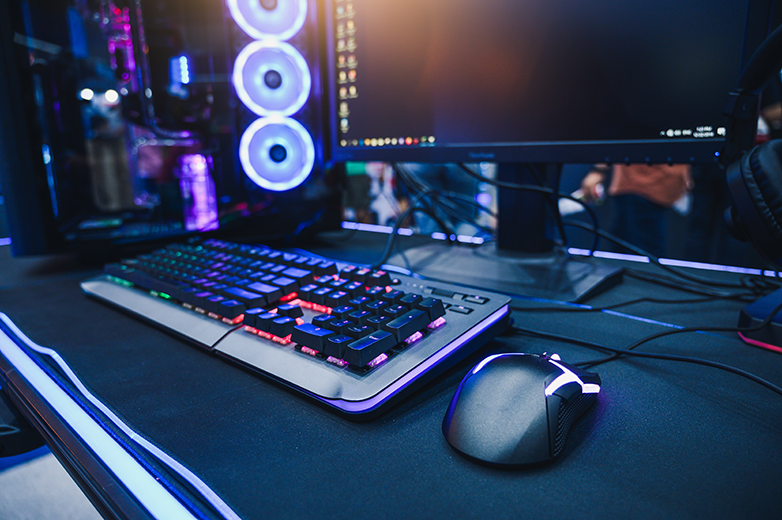 Image of a gamer's desk consisting of the desktop computer and gaming gear.